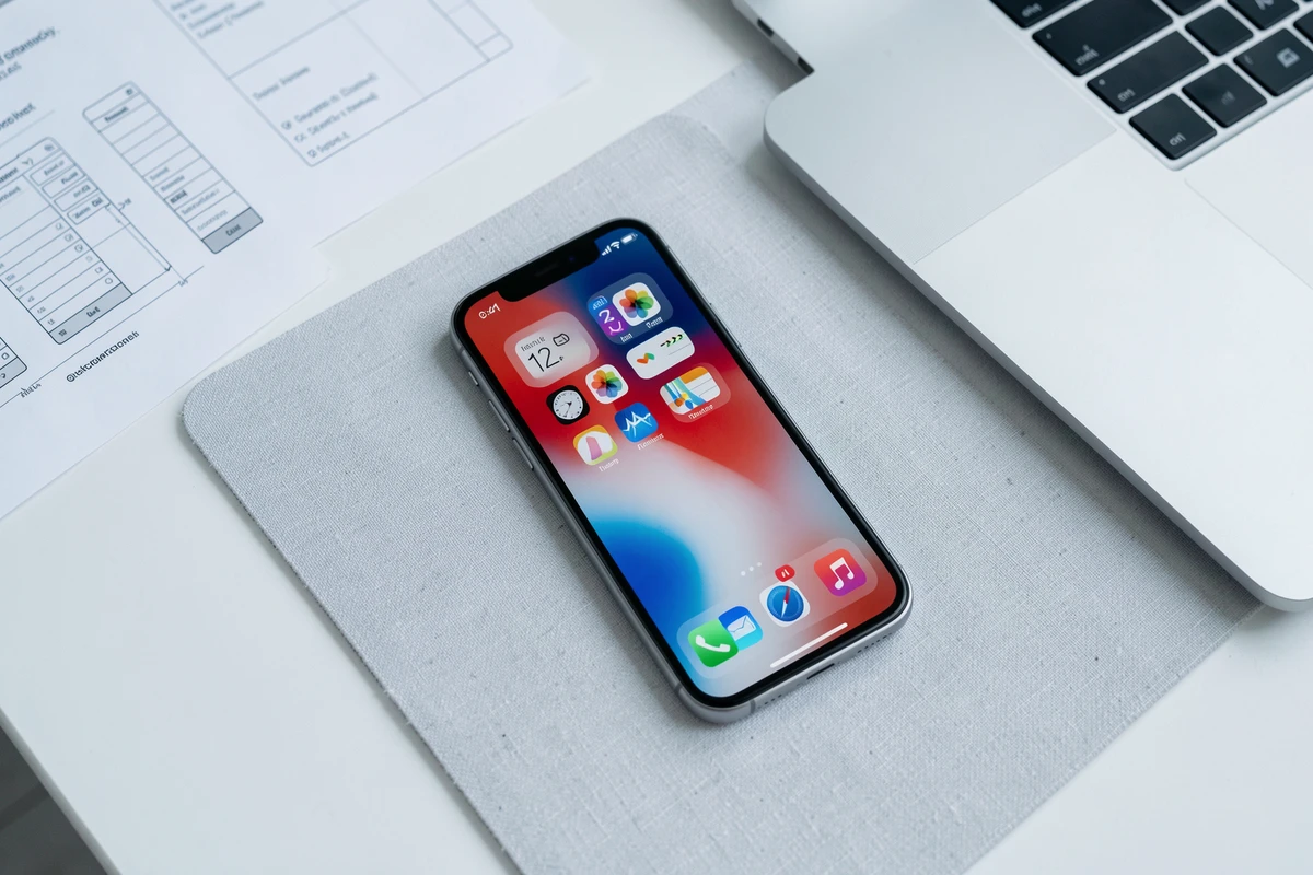 Maquette de l'interface iOS révélant des indices sur le design du prochain iPhone SE posé sur un bureau minimaliste